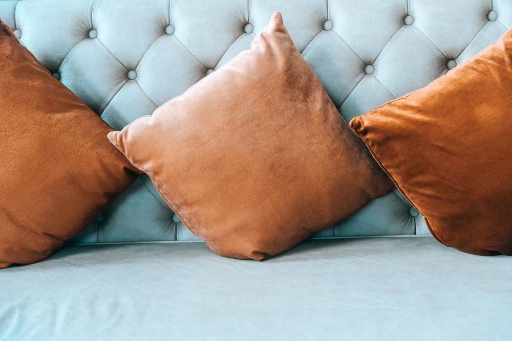 cojines marrones sobre sofa azul